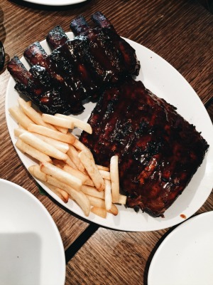 grilled ribs coated with generous amount of barbeque sauce, with fries