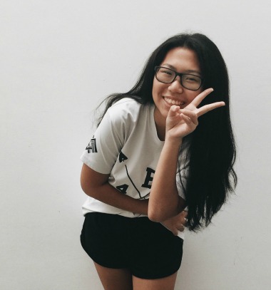black haired girl smiling with peace sign